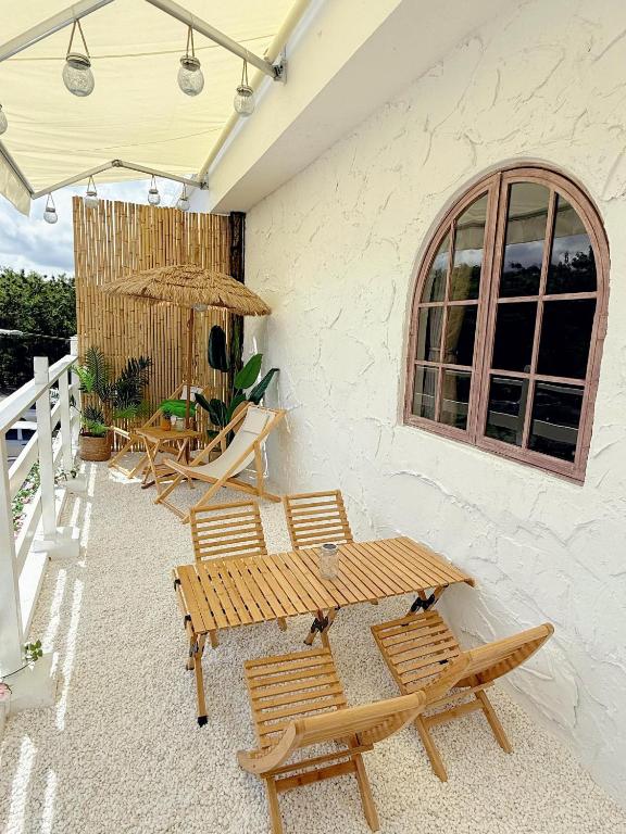a patio with two benches and a table and chairs at The Cozy Cottage Semporna in Semporna