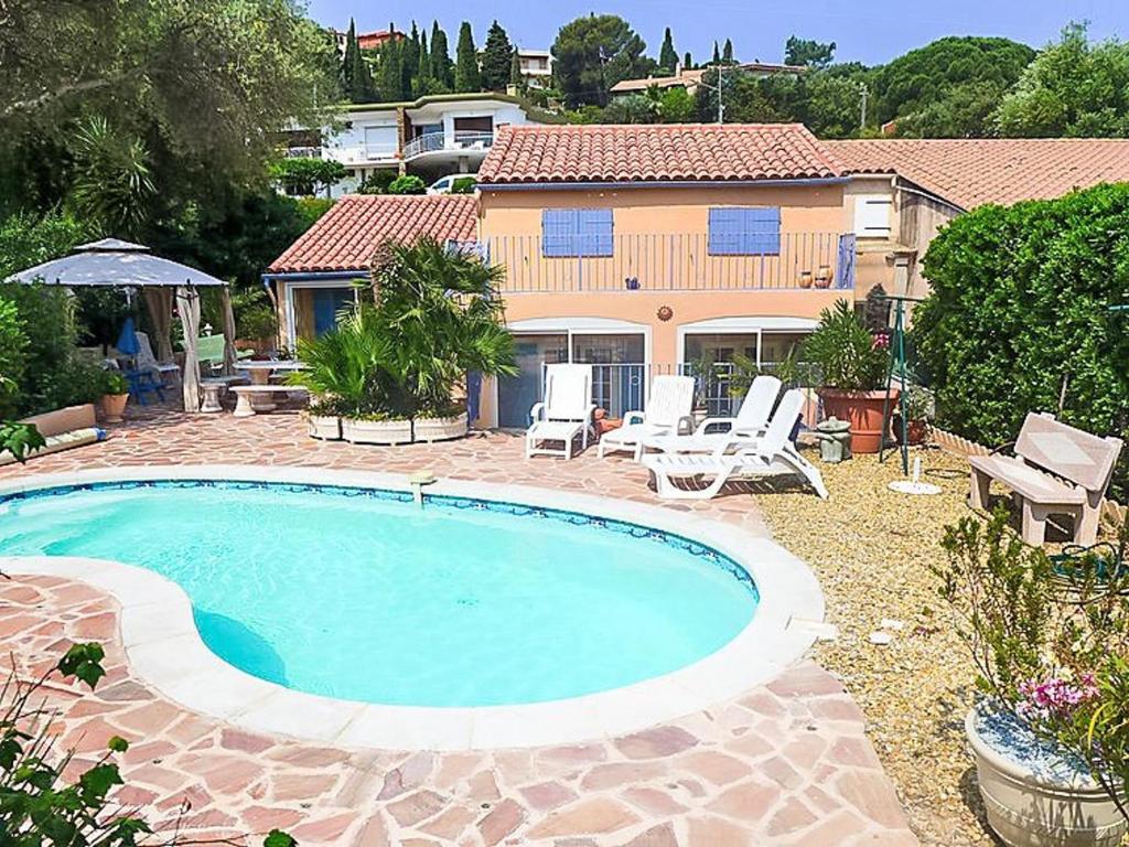 une piscine devant une maison dans l'établissement Villa 5 pièces avec piscine privée près de la plage au Lavandou - FR-1-251-852, au Lavandou