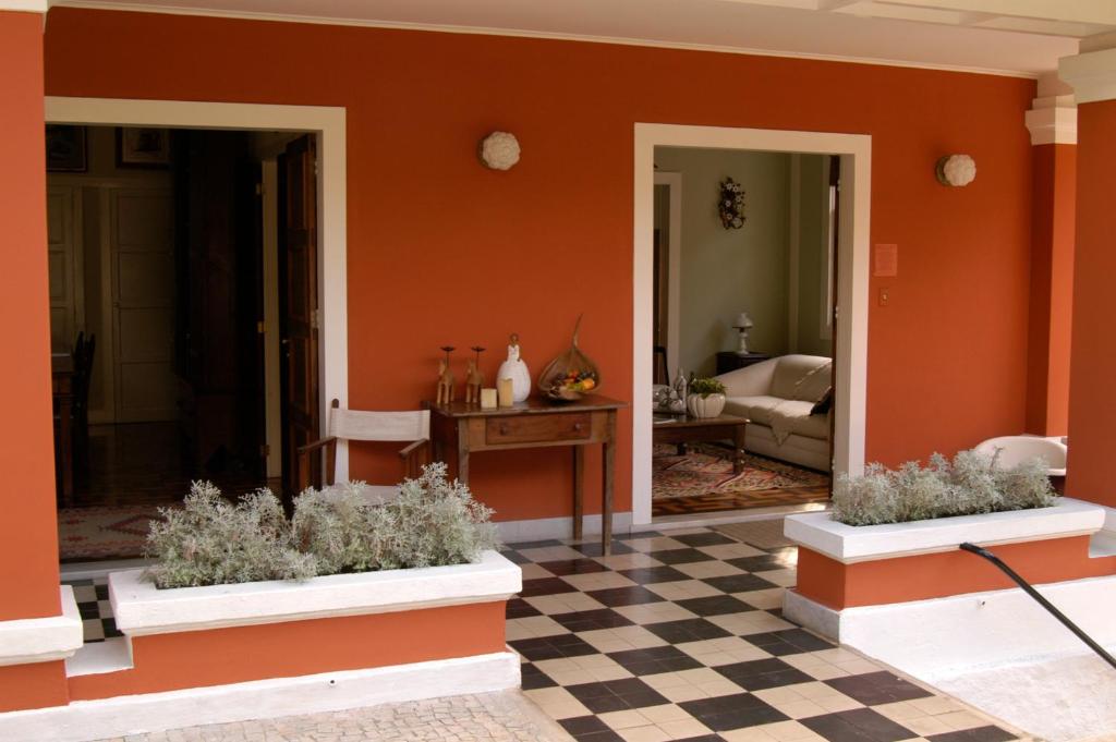 sala de estar con paredes de color naranja y suelo a cuadros en Casa Vila Brasil - Centro Histórico, en Petrópolis