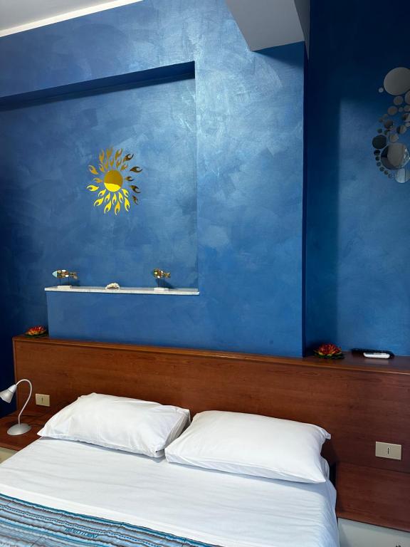 1 dormitorio con una pared azul y 1 cama en La Dea del mare, en Scilla
