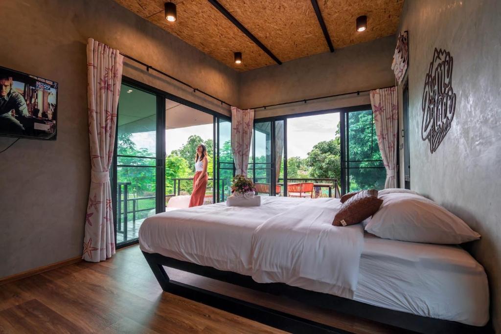 a bedroom with a large bed and a balcony at 2Someplace in Ban Pang Mung