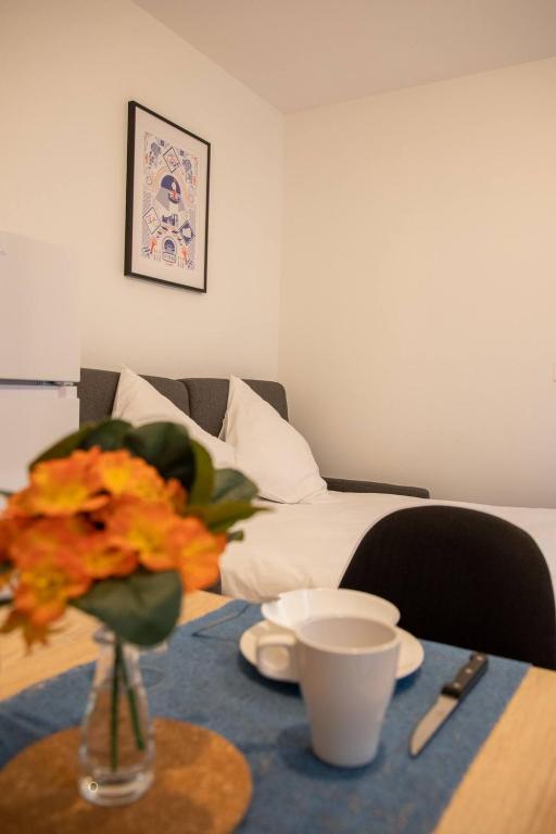 une table avec un vase de fleurs sur une table et un lit dans l'établissement La Tulipe - Confortable - un véritable cocon, à Niort
