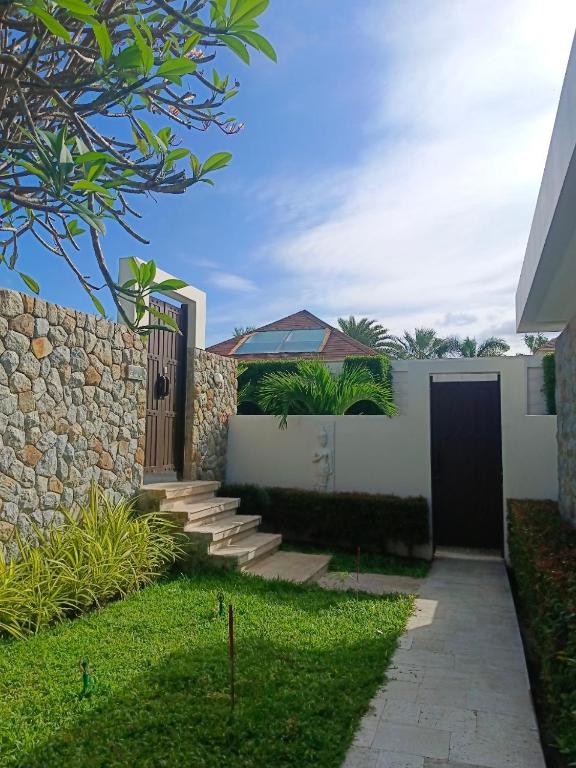a house with a gate and a stone wall at Skye Beach Hotel - Koh Samui in Choeng Mon Beach