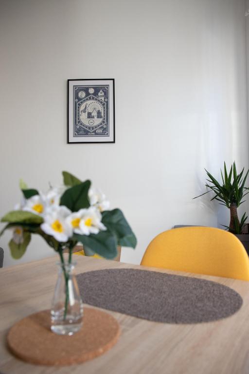 un vase de fleurs assis au-dessus d'une table dans l'établissement L'Amsterdam - Duplex trés calme au dernier étage, à Niort