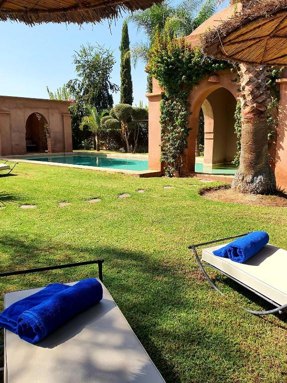 two blue pillows sitting on a table next to a pool at Private Villa at Jardins de Touhina in Marrakesh