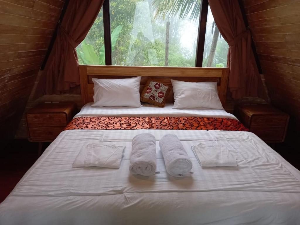 a bed in a room with two towels on it at VIP Homestay Lemukih in Singaraja