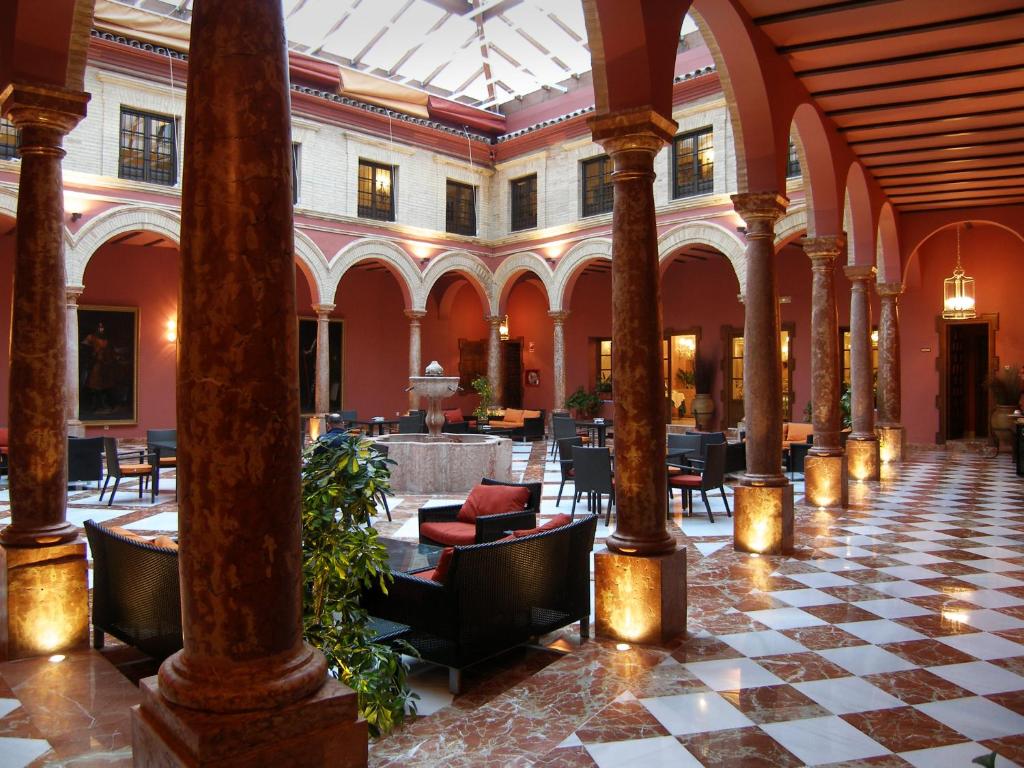 een lobby met stoelen en tafels in een gebouw bij Hotel Santo Domingo Lucena in Lucena