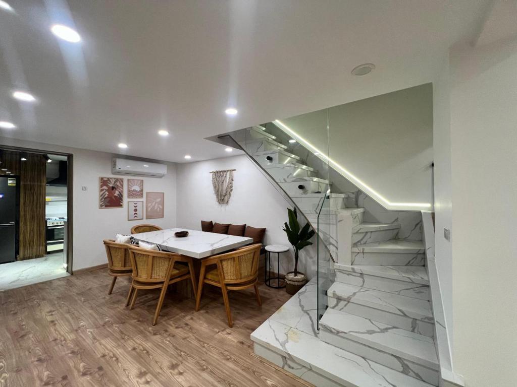 a dining room with a table and a staircase at Duplex 3Bedroom Apartment Overlooking Giza Zoo Perfect for Families and Friends in Cairo