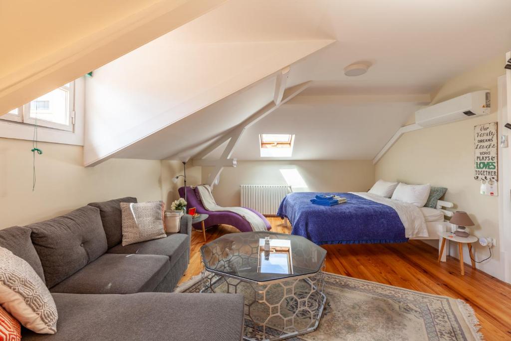 a living room with a couch and a bed at Sky Accommodations Studio in Coimbra