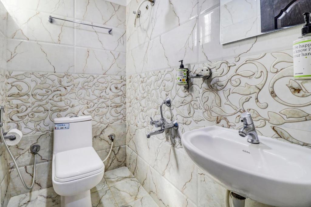 a bathroom with a sink and a toilet at Hotel Namo Again By IGI in New Delhi