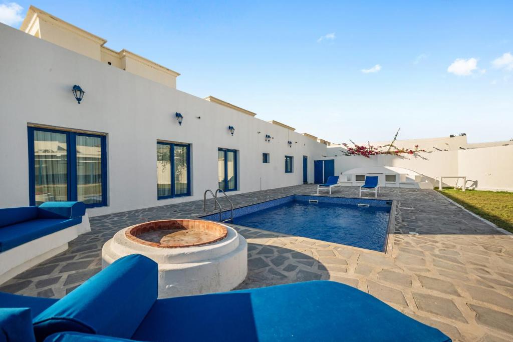 a backyard with a swimming pool and a house at Dreams Gate Villa Resthouse 4 in Umm Şalāl ‘Alī