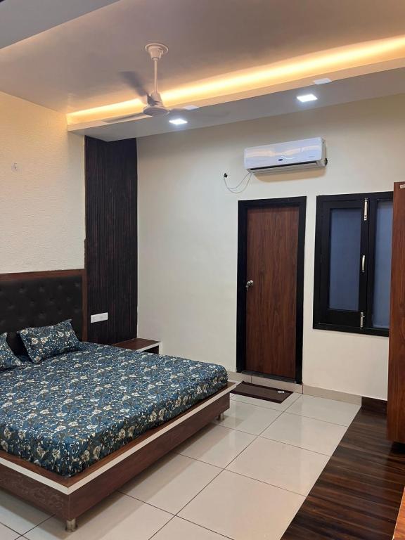 een slaapkamer met een bed en een plafondventilator bij Phoenix Wedding & HomeStay in Amritsar