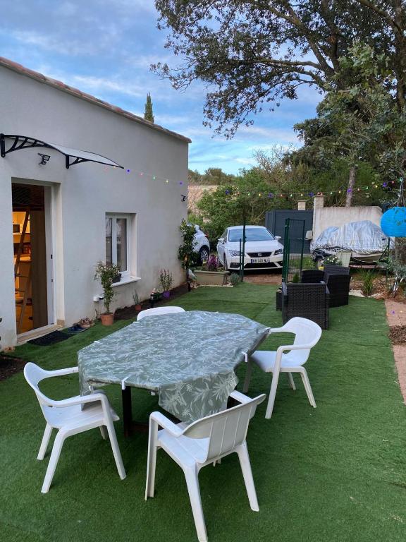 un patio avec une table et des chaises sur l'herbe dans l'établissement Maison neuve à 15 min de Cassis, à Roquefort-la-Bédoule