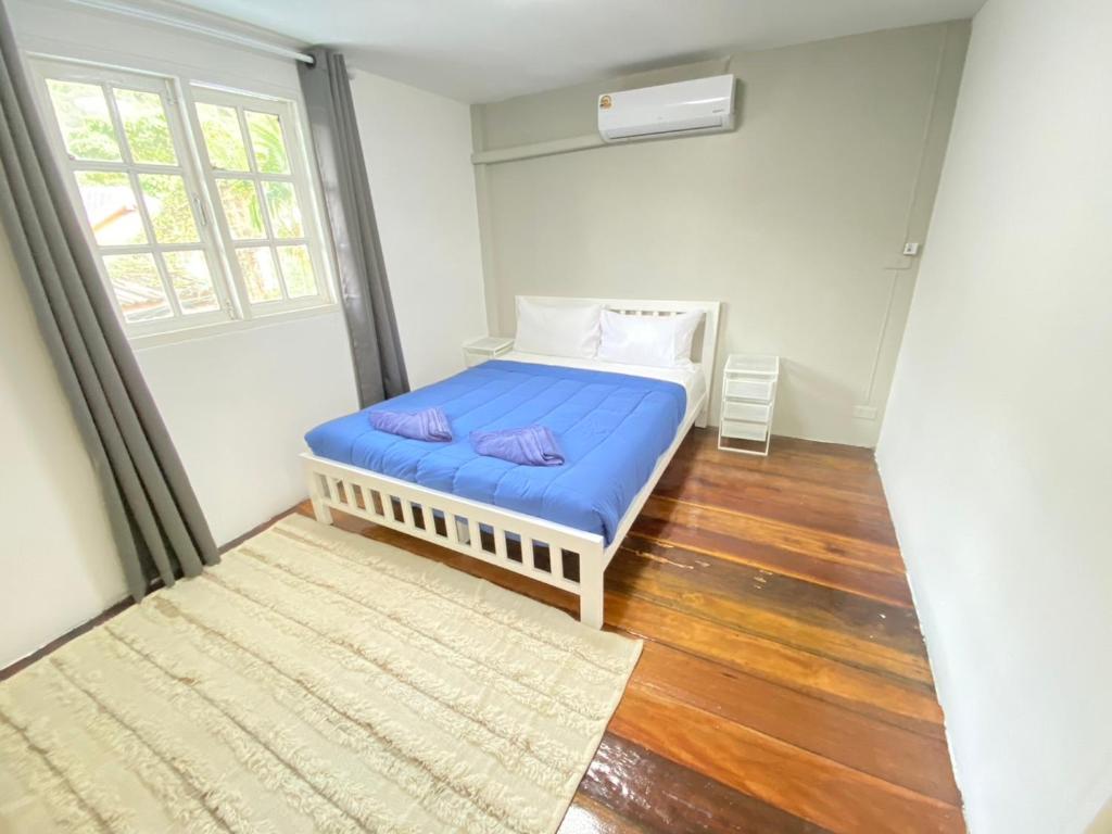 a small bedroom with a blue bed and a window at Cozy townhouse near by Klong Dao beach in Ban Mo Nae