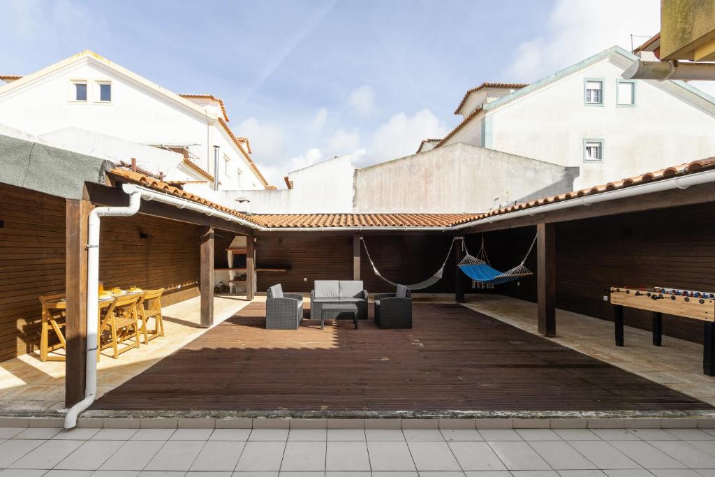 an outdoor area with a wooden deck with a table and chairs at Casa da Barragem in Atouguia da Baleia