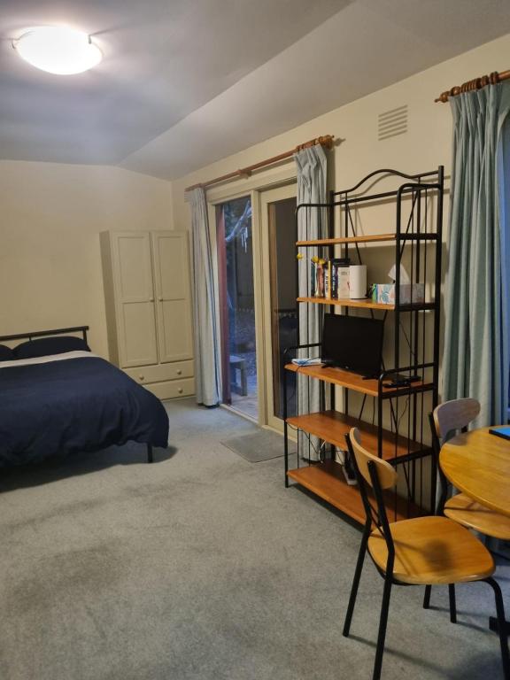 a bedroom with a bed and a table and a chair at Garden Dreams bungalow in Blackburn