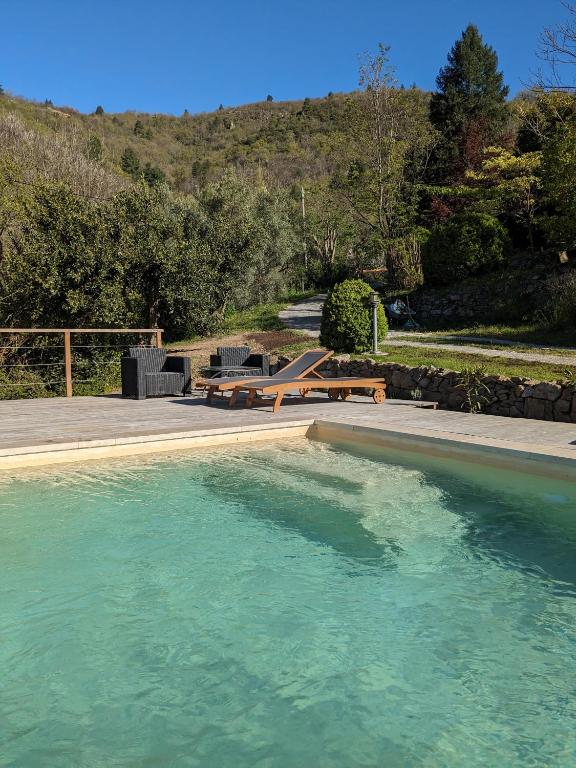un bassin d'eau avec une table de pique-nique et des bancs dans l'établissement Mas du ciel en Cévennes, à Arphy