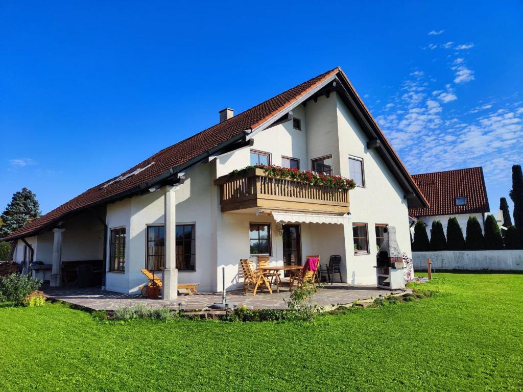 a white house with a balcony and a yard at Richie's Landhaus im Allgäu in Pfaffenhausen