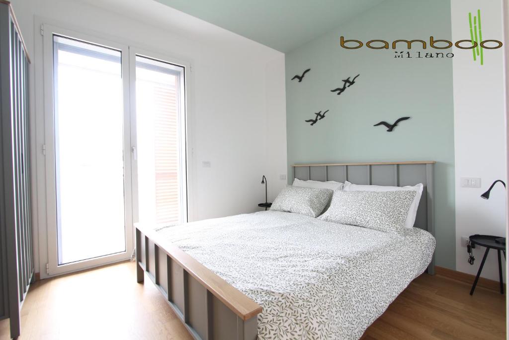 une chambre avec un lit avec des chauves-souris sur le mur dans l'établissement Bamboo Milano Rutilia, à Milan
