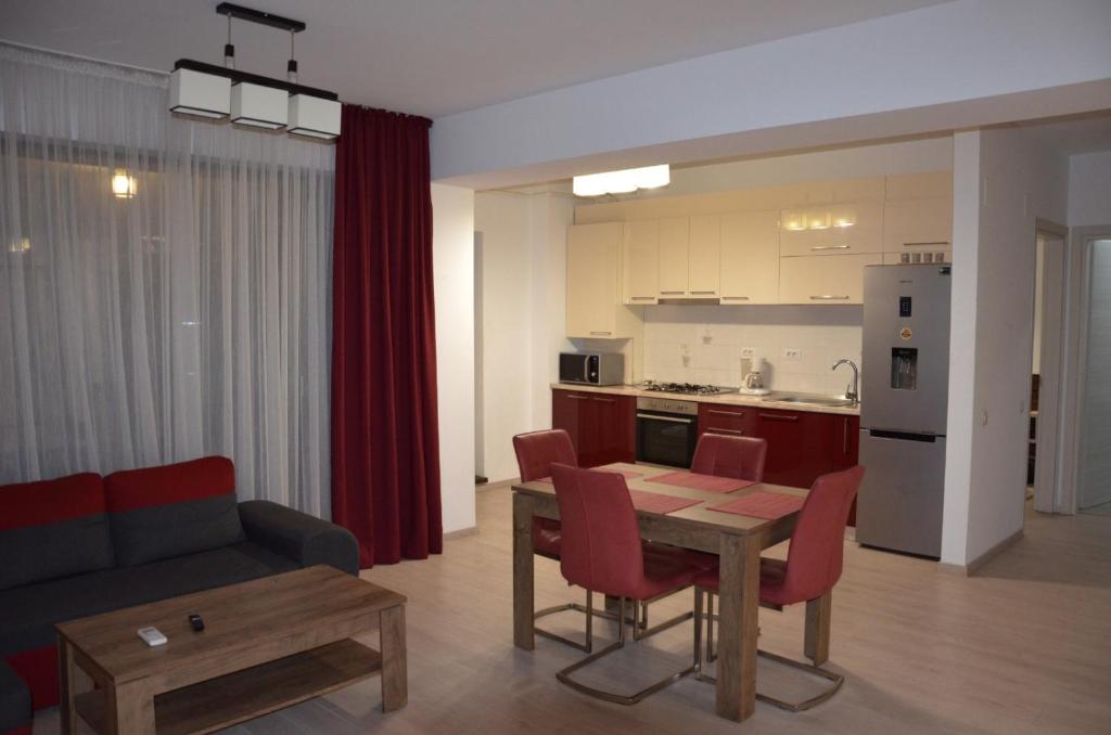 a living room with a table and a kitchen at Bujorului Residence - 2Br Apartament Central in Craiova
