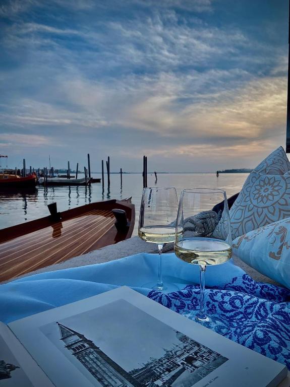 a table with two wine glasses sitting on a boat at Venetian Dreams - Giudecca in Venice