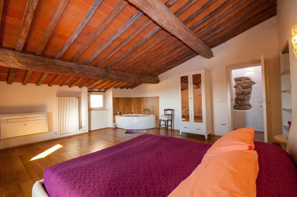 um quarto com uma cama roxa e uma banheira em Castle Holiday Home em Castagneto Carducci