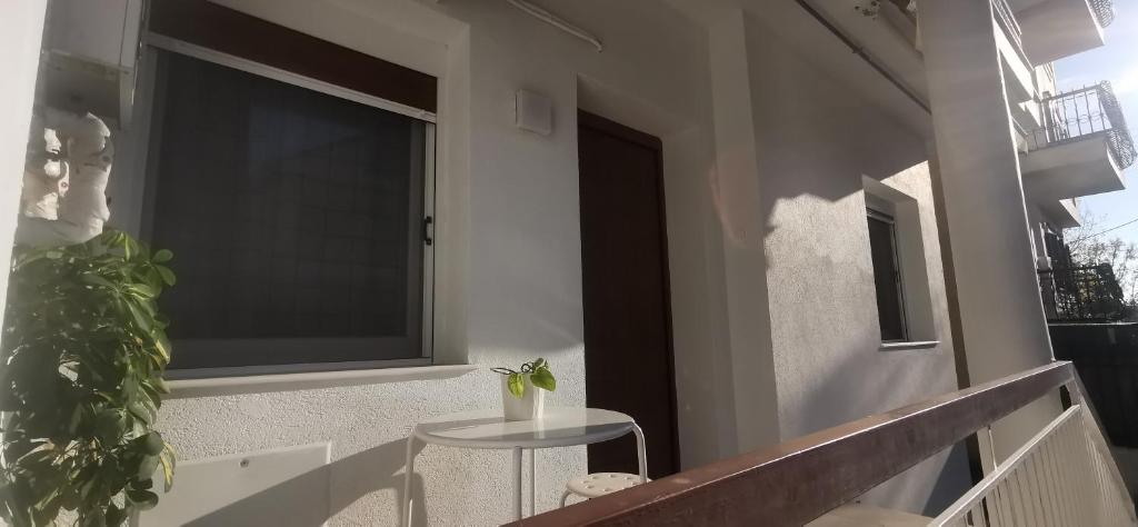 d'un balcon avec une table et une grande fenêtre. dans l'établissement Nea Elvetia Metro Station apartment Thessaloniki-Νέα Ελβετία Στάση Μετρό Θεσσαλονίκη, à Thessalonique