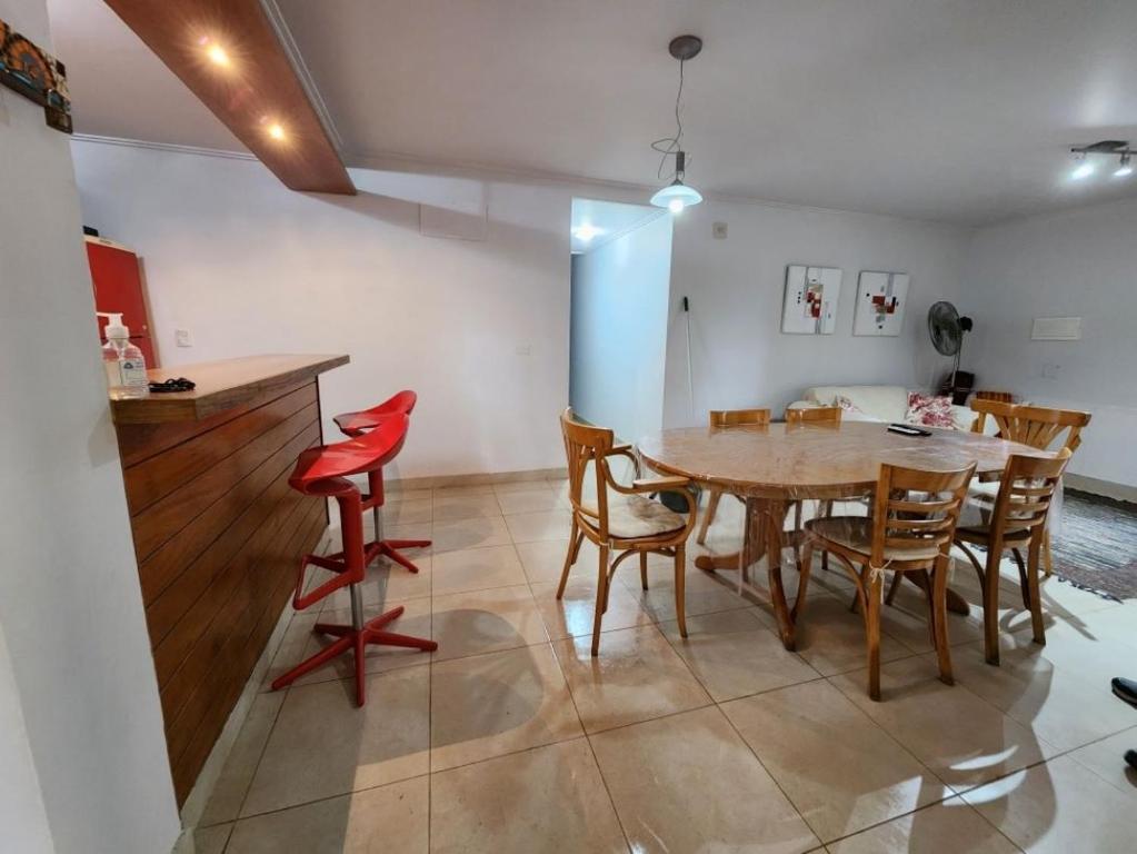 eine Küche und ein Esszimmer mit einem Holztisch und Stühlen in der Unterkunft Lago los Molinos Punto Claro villa Silvestre depto 2 dorm y cochera in Villa Ciudad Parque