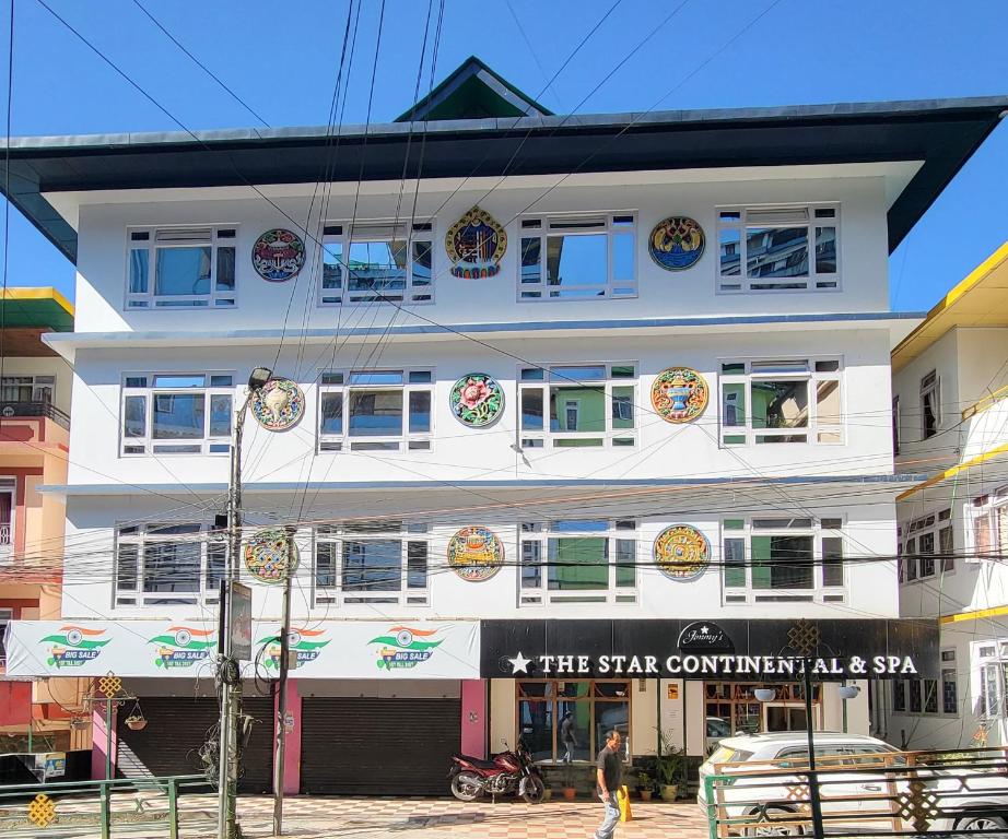 a tall white building with a sign on it at The Star Continental & Spa Gangtok in Gangtok