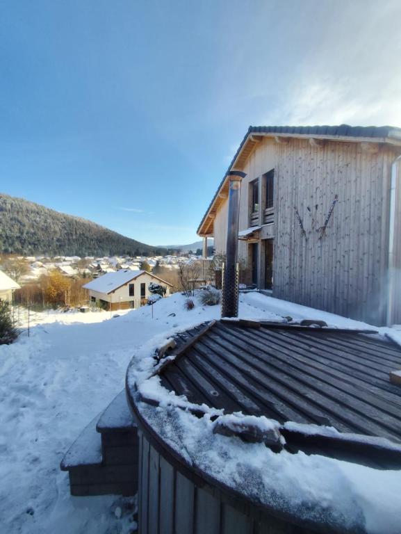 une maison avec de la neige sur le toit dans l'établissement Chalet du Nid d'amour, à Gérardmer