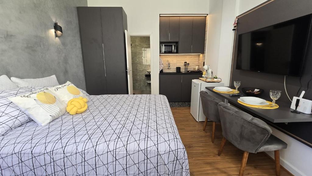 Un dormitorio con una cama y una mesa y una cocina. en Loft Moderno e Aconchegante a Dois Passos da Feirinha do Alto!, en Teresópolis