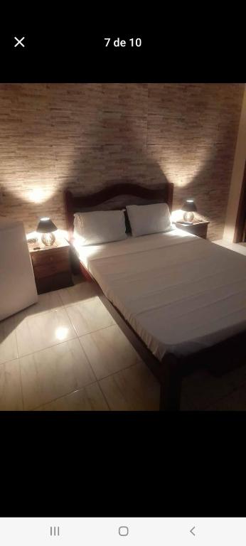 a bedroom with a large bed with lights on it at Suítes in Fonseca