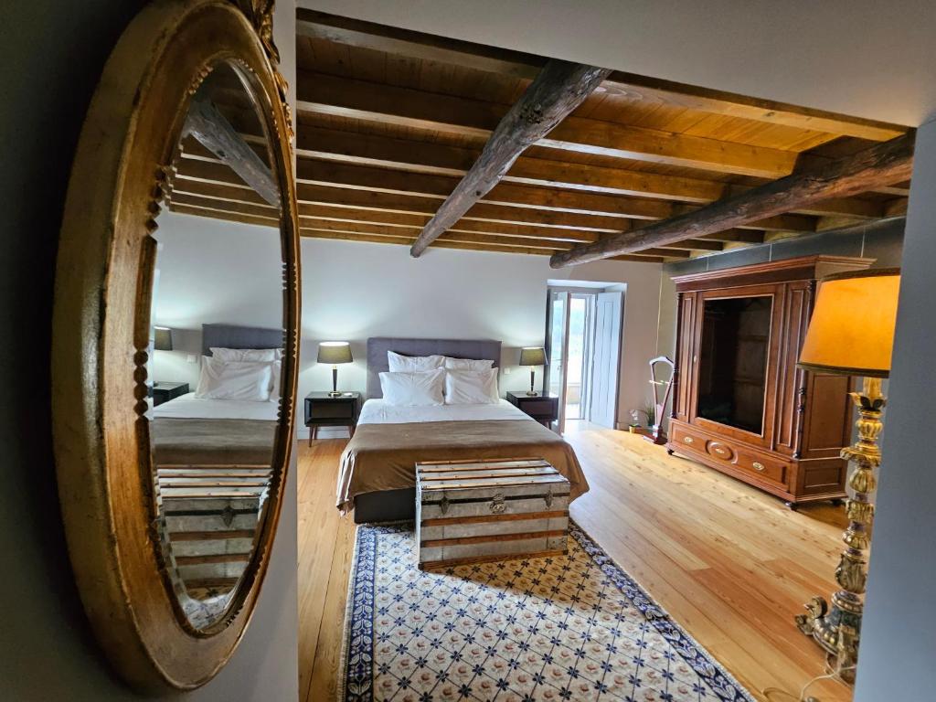 Un dormitorio con una cama grande y un espejo. en Burgo da Villa, en Castelo de Vide
