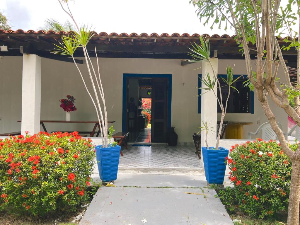 a house with blue pots of flowers in front of it at Sítio Caju in Aquiraz