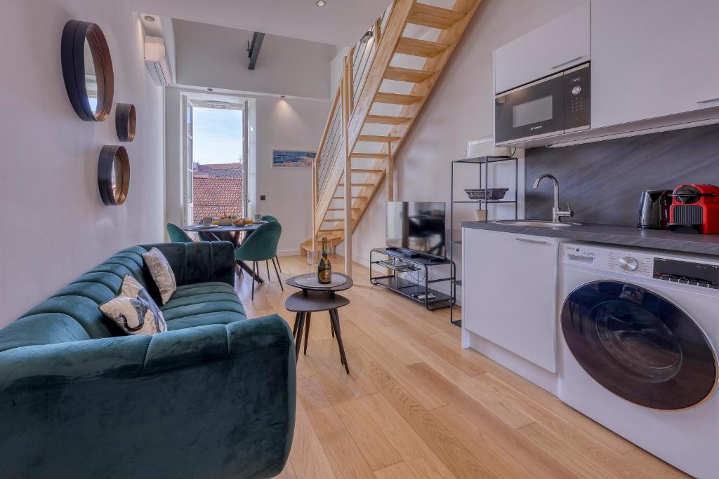 un salon avec un canapé vert et une cuisine dans l'établissement Loft Croisette Standing Presta, à Cannes