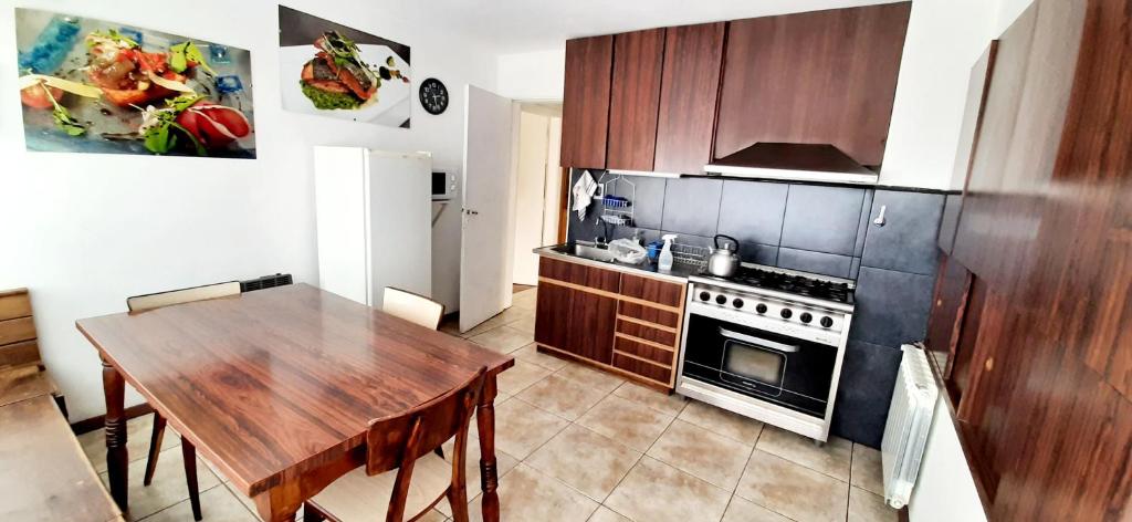 a kitchen with a wooden table and a kitchen with a stove at CASA PARA 4-6 PERSONAS 2 dorm A POCAS CUADRAS DEL CENTRO DE BARILOCHE in San Carlos de Bariloche