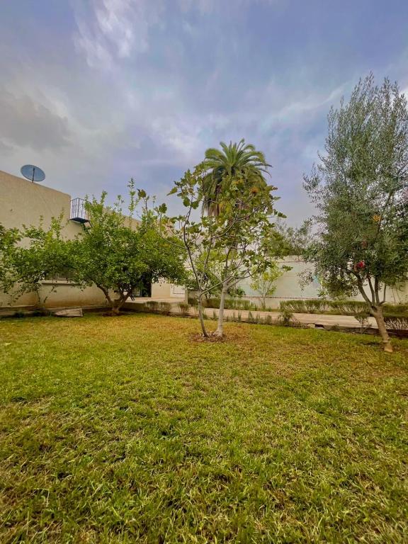 a yard with trees in front of a building at Achraf Immo in Fez