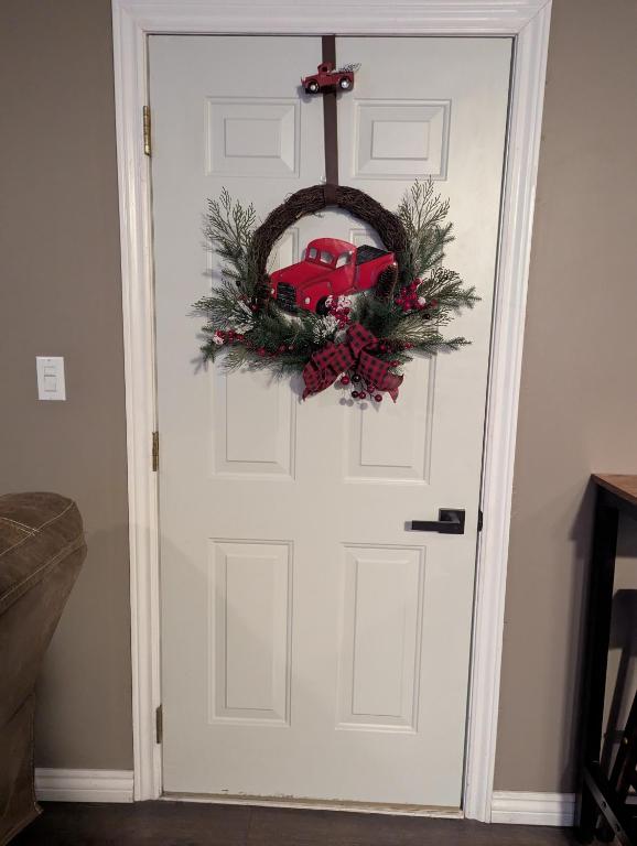 a door with a christmas wreath and a red truck on it at Suite in the Bush-Private Apartment in Bancroft