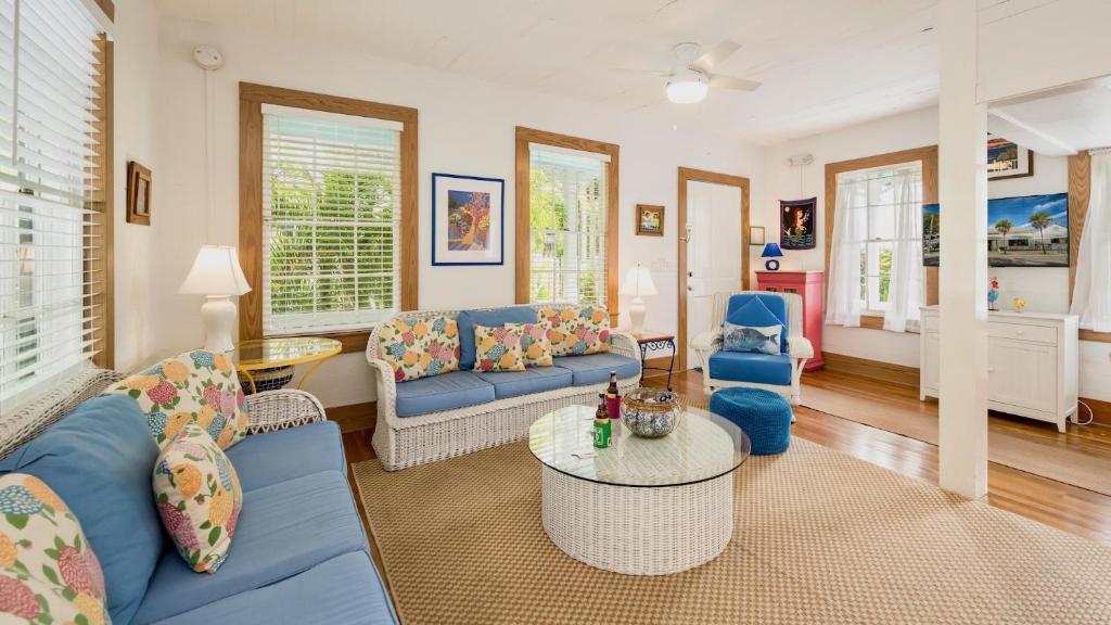 a living room with blue couches and a table at Casa Serendipity by Last Key Realty in Key West