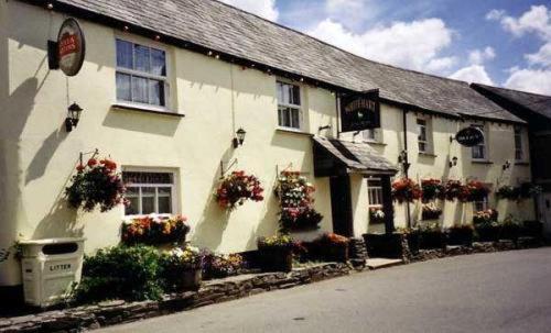 a white house with flower boxes on the side of it at The White Hart Hotel in Liskeard