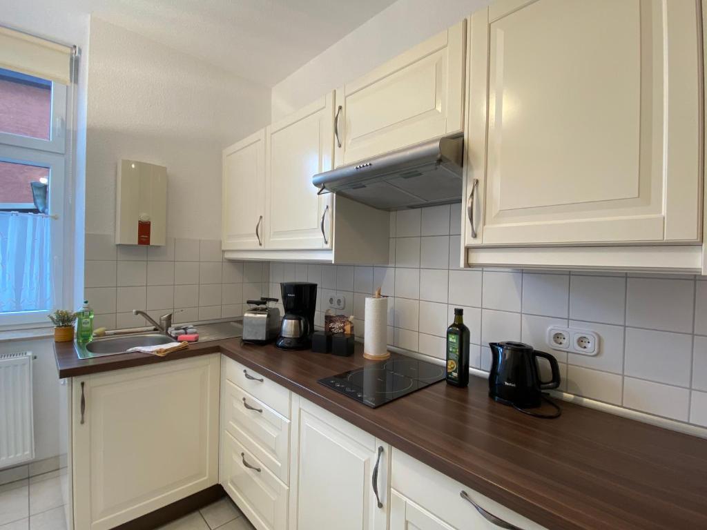 une cuisine avec des armoires blanches et un comptoir en bois dans l'établissement Apartment Camino Living, à Bautzen