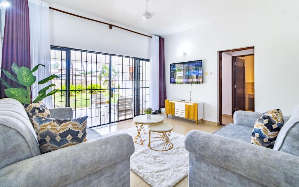 a living room with two couches and a table at Luxury 3 bedroom beach front apartment in Mombasa