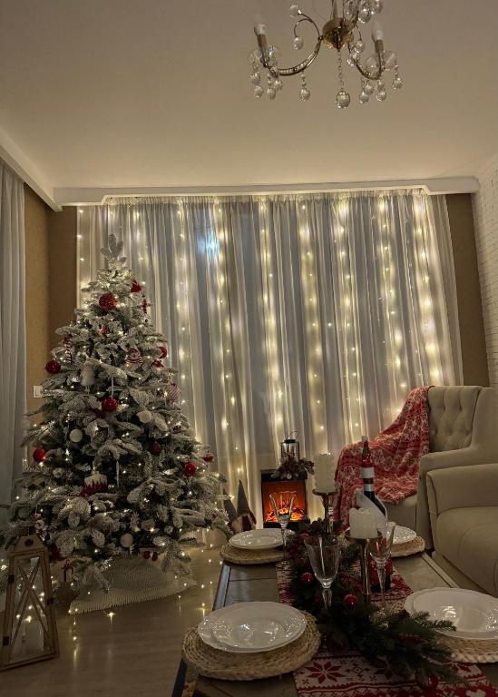a christmas tree in a living room with a couch at Tamari See in Dedoplis Tskaro
