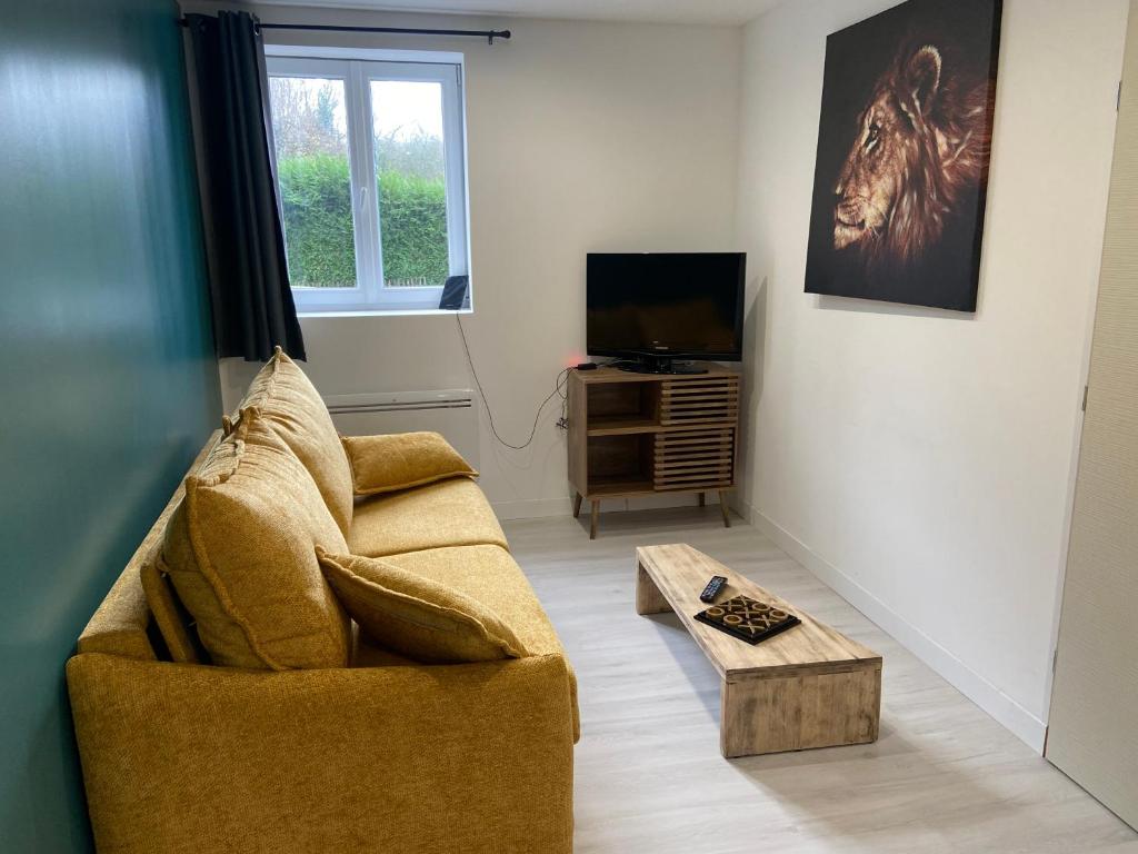 a living room with a couch and a coffee table at Joli studio au calme in Bruay-la-Buissiere