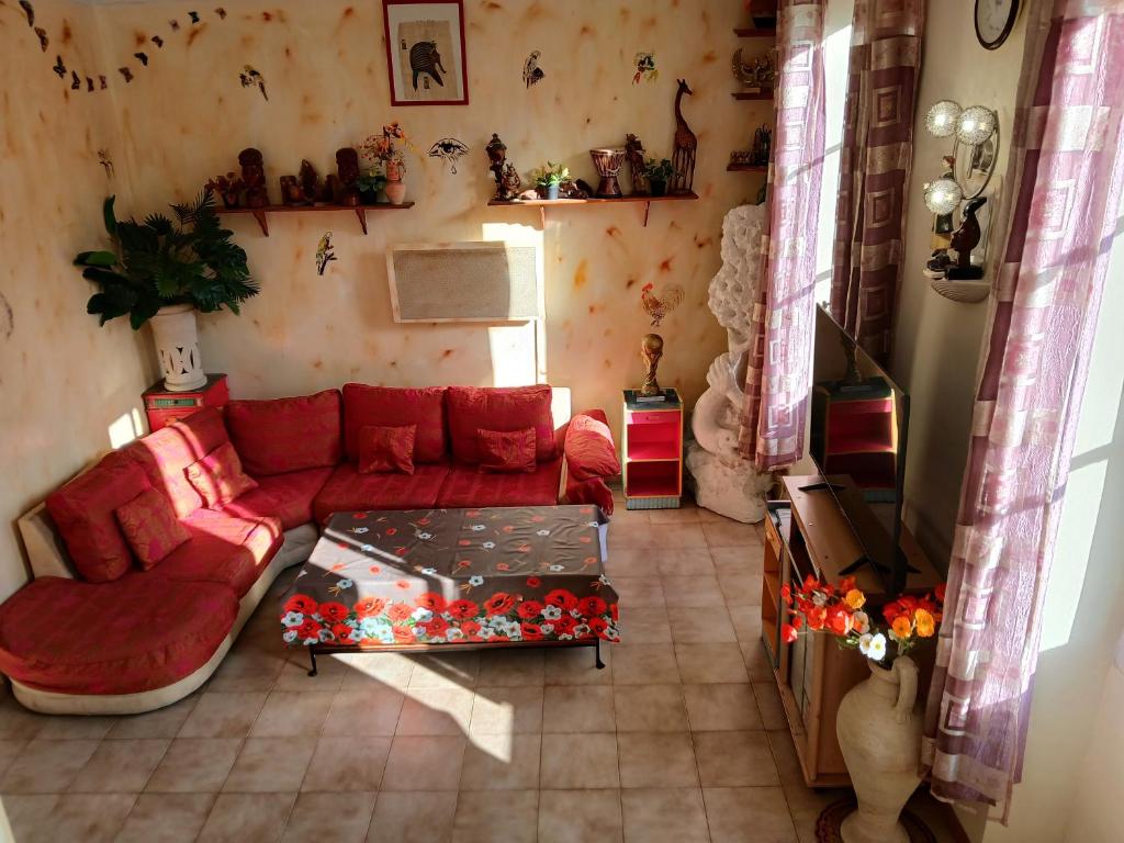 Una sala de estar con un sofá rojo y una mesa. en Marseille loft américain centre ville 7 personnes, en Marsella