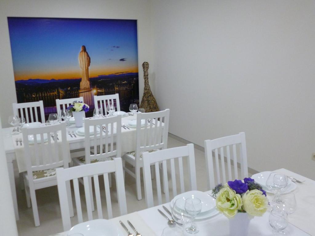 een witte eetkamer met witte tafels en witte stoelen bij Hotel Stana in Međugorje