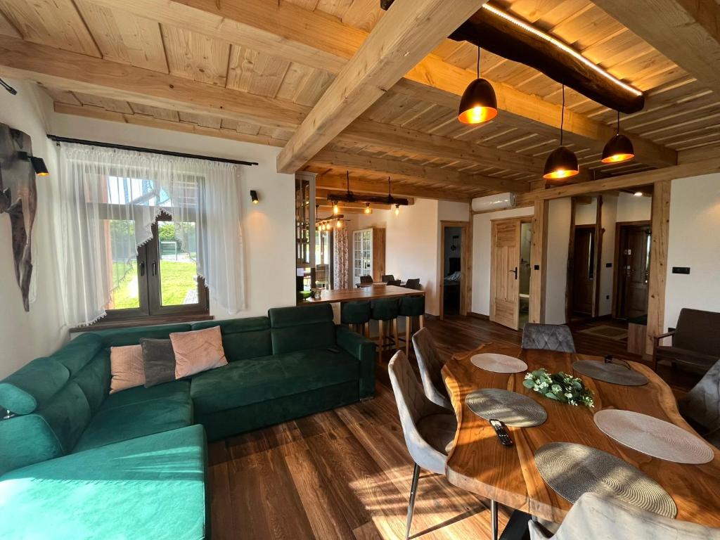 a living room with a green couch and a table at Julia Vendeghaz Fony in Fony