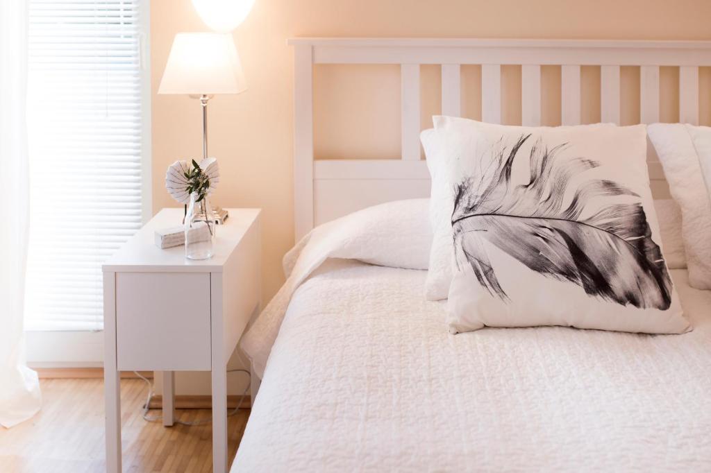 a bedroom with a white bed with a black and white pillow at Parkside Apartment House in Düsseldorf