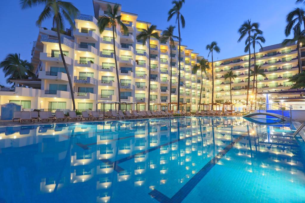 a hotel with a swimming pool in front of a building at Crown Paradise Golden All Inclusive Resort - Adults Only in Puerto Vallarta