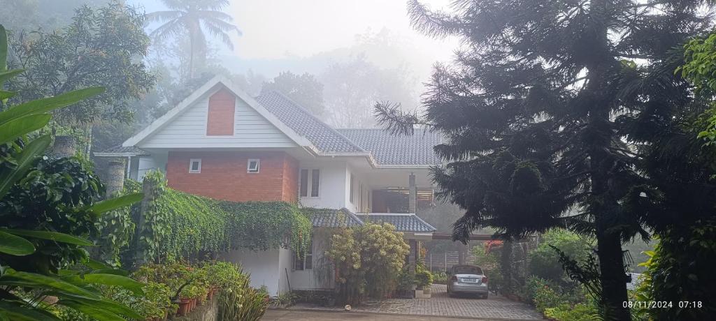 a house with a car parked in front of it at Nadackal Nature County in Munnar